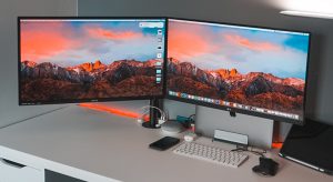 two monitors on white desk